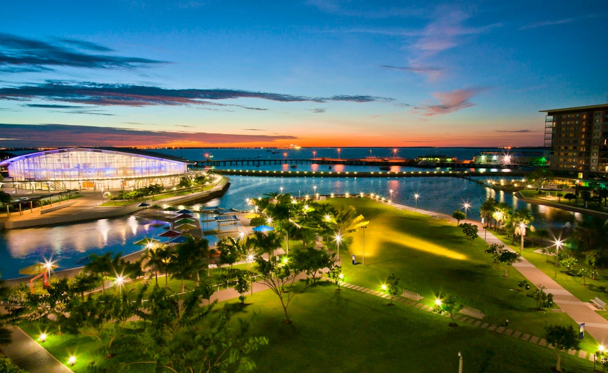 aerial photograph of the waterfront at night time, lit up with building lights